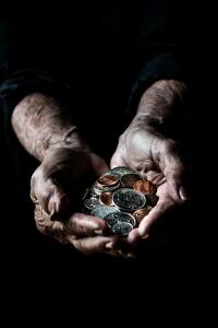African American elderly hands holding a handful of change.